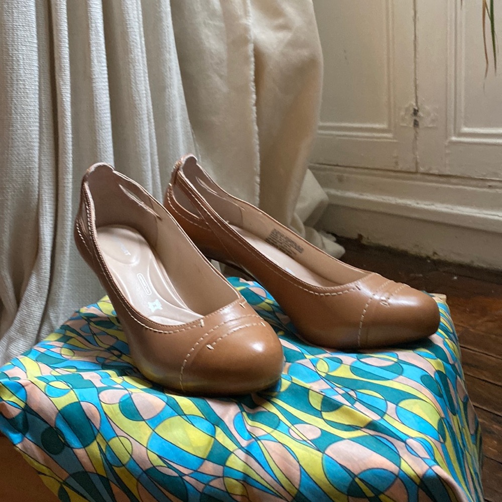 Neutral brown leather Rockport pumps with white top stitching.